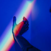 Hand touching a rainbow on the wall