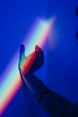 Hand touching a rainbow on the wall
